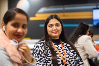 A student looking confidently at the camera in a learning space. The focus suggests interaction in a group setting.