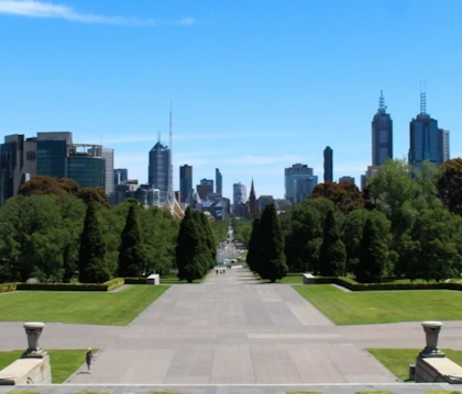 A clear day in Melbourne, showing an empty park with towering skyscrapers in the distance